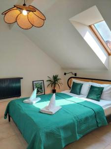 a bedroom with a large green bed with two pillows at Apartament z 1 Sypialnią przy Rynku w Żywcu in Żywiec
