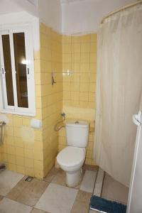a bathroom with a toilet and a window and yellow tiles at Casa servantes in Tangier