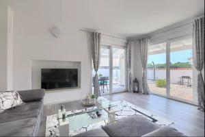 un salon avec un canapé et une télévision dans l'établissement Villa Sarah Medulin, à Medulin