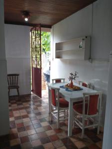 a kitchen with a table and chairs in a room at Suites Delicia in Passa Quatro