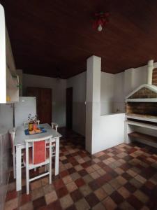 a small kitchen with a white table and chairs at Suites Delicia in Passa Quatro +8 photos