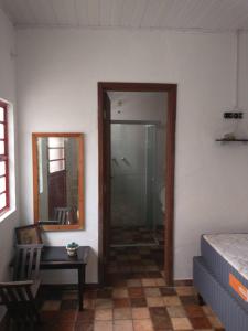 a bedroom with a glass door leading to a shower at Suites Delicia in Passa Quatro