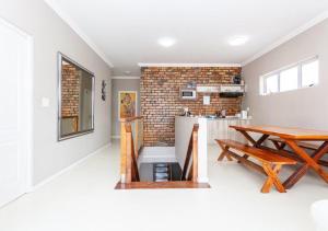 a dining room with a table and a brick wall at BKaap2 Queens and Kings Guest House in Cape Town