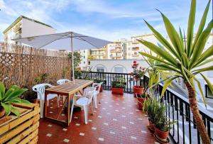 a patio with a table and chairs and an umbrella at Foce24 - City Garden - in Imperia