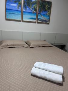 a bed with two towels on it with two windows at Bioflora Residence Itacimirim in Camacari +33 photos