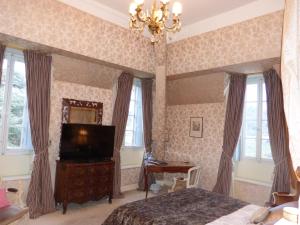 a bedroom with a bed and a flat screen tv at Chateau d'Urbilhac in Lamastre