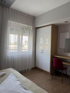 a bedroom with a bed and a desk and a cabinet at Apartmants S&H in Ulcinj