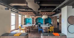 a room with tables and chairs and blue walls at Delft Apartemen CPI in Tanjungbunga