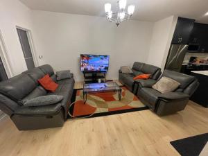 a living room with two couches and a flat screen tv at Bedroom in Upland D in Edmonton