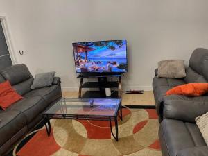 a living room with two couches and a flat screen tv at Bedroom in Upland D in Edmonton