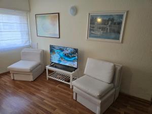 a living room with two chairs and a television at Los Dedos in Punta del Este