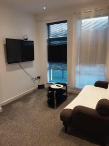 a bedroom with a bed and a flat screen tv at Three bedroom apartment Darlington Victoria Road in Darlington