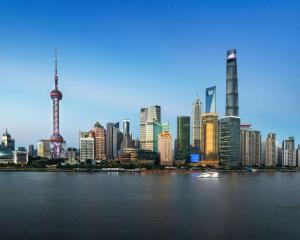 上海Pudong Shangri-La Shanghai - With a sweeping view of the Pearl Tower and the historic Bund skyline的有河流和建筑物的城市天际线