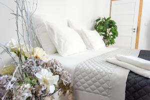 Penzion Apartmány Hradební في أوهيرسك هراديست: غرفة نوم بسرير مع مخدات بيضاء وزهور