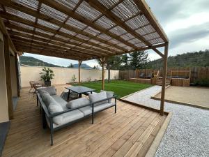 a patio with a couch under a wooden pergola at La Maison Myrtille in Castellane