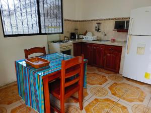 a kitchen with a table and chairs and a refrigerator at Teresita's House - Suites con cocina privada in Puerto Baquerizo Moreno