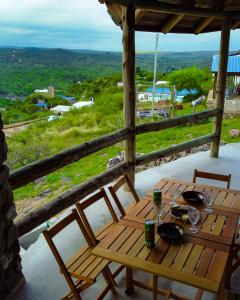 a wooden table and chairs sitting on a porch at La Richard Refugio Boutique in Dique Nivelador