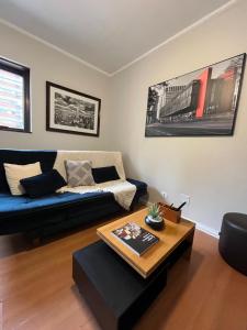 uma sala de estar com um sofá azul e uma mesa de centro em Jardim Paulista - Design & Confort - Pool - Parking - Wi-Fi - 24h em São Paulo