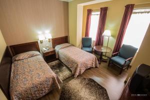 una habitación de hotel con 2 camas y una silla en Hotel Regency, en Korçë