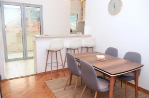 a dining room with a wooden table and chairs at Zlatna Boska in Kotor