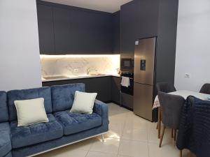 a living room with a blue couch and a kitchen at 3 rooms apartment in vlora in Vlorë