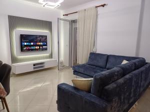 a living room with a blue couch and a tv at 3 rooms apartment in vlora in Vlorë