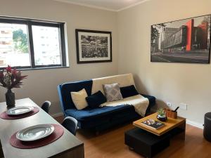 uma sala de estar com um sofá azul e uma mesa em Jardim Paulista - Design & Confort - Pool - Parking - Wi-Fi - 24h em São Paulo mais 35 fotografias