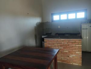 a kitchen with a brick fireplace and a window at casa do conde in Luis Correia