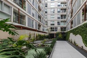 a courtyard of an apartment building with plants at Confortable apartamento en Miraflores cerca del malecón C1 in Lima