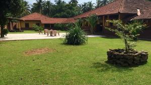 a small tree in a yard next to a house at Sigiri Villas in Kandawala