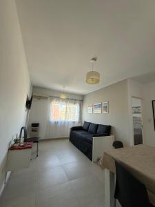 una sala de estar con un sofá y una mesa en Apartamentos Holdich, en Bahía Blanca