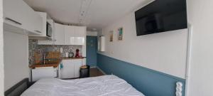 a small room with a bed and a kitchen at superbe studio avec piscine, ascenseur et accès direct sur le port in Cap d'Agde