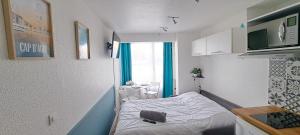Cette petite chambre comprend un petit lit et une cuisine. dans l'établissement superbe studio avec piscine, ascenseur et accès direct sur le port, au Cap d'Agde