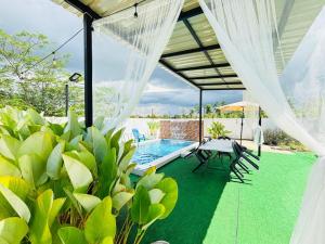 a patio with a table and chairs and a pool at Cikyu Homestay Private Pool Setiu in Kampung Rahmat
