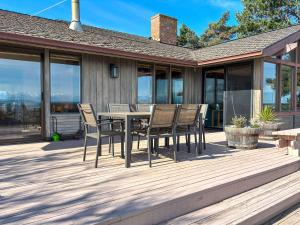 a wooden deck with a table and chairs on it at Sq Secret Garden in Sequim