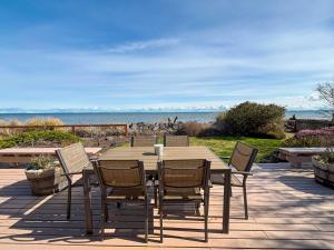 a wooden table and chairs with the ocean in the background at Sq Secret Garden in Sequim