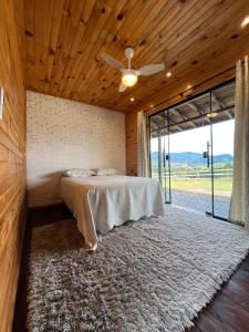 a bedroom with a bed and a ceiling fan at Casa da Colina - Campo Novo in Bom Retiro