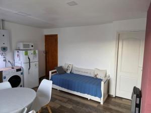 a bedroom with a bed and a refrigerator and a table at Sur Bonito in Río Grande