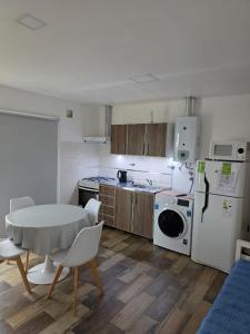 eine Küche mit einem Tisch und einem weißen Kühlschrank in der Unterkunft Sur Bonito in Río Grande