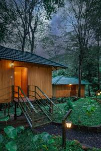 een klein houten huisje met een trap die naar het huisje leidt bij De Spicewoods, AC Cabin, Pool, Couple only in Kalpatta