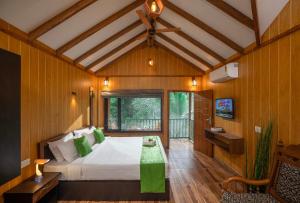 een slaapkamer met een bed in een kamer met houten wanden bij De Spicewoods, AC Cabin, Pool, Couple only in Kalpatta