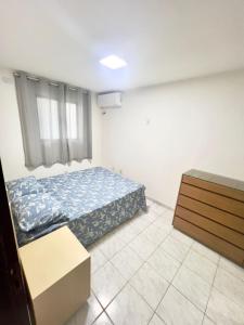 a bedroom with a bed and a dresser in it at Beach Mar de Gênova 202- Espaço & Conforto Praia Bessa in João Pessoa