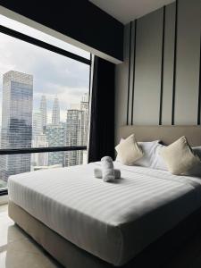 a large bed in a room with a large window at The Axon Suites Pro Max in Kuala Lumpur