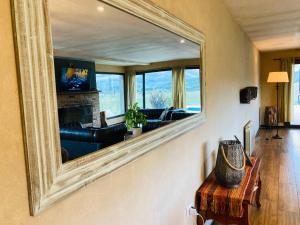 ein Wohnzimmer mit einem großen Spiegel an der Wand in der Unterkunft Casa Patagonia in San Martín de los Andes
