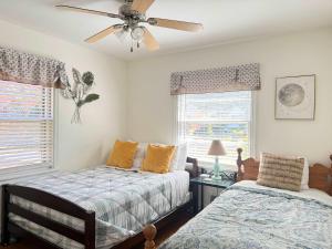 a bedroom with two beds and a ceiling fan at RF Central location w fenced backyard FIRE-PIT in Richmond