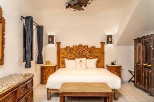 Un dormitorio con una cama grande con cabecero de madera. en 5 Frogs Hotel Bucerias, en Bucerías 259 fotos más