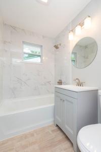 Un baño blanco con bañera y lavabo. en 3 bedrooms 2 bathrooms Charming Gulfport home near the beach, en San Petersburgo