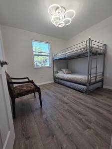 Un dormitorio con dos literas y una silla. en 3 bedrooms 2 bathrooms Charming Gulfport home near the beach, en San Petersburgo