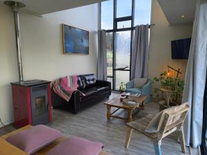 a living room with a couch and a table at Coyhaique, CASA LAVANDA in Coihaique