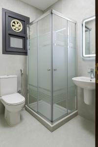 a bathroom with a shower and a toilet and a sink at Discover Tranquility by the Sea at Porto Said Resort in Port Said